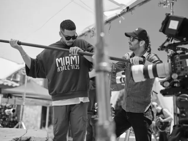 Production sound mixer booming a scene beside the camera operator